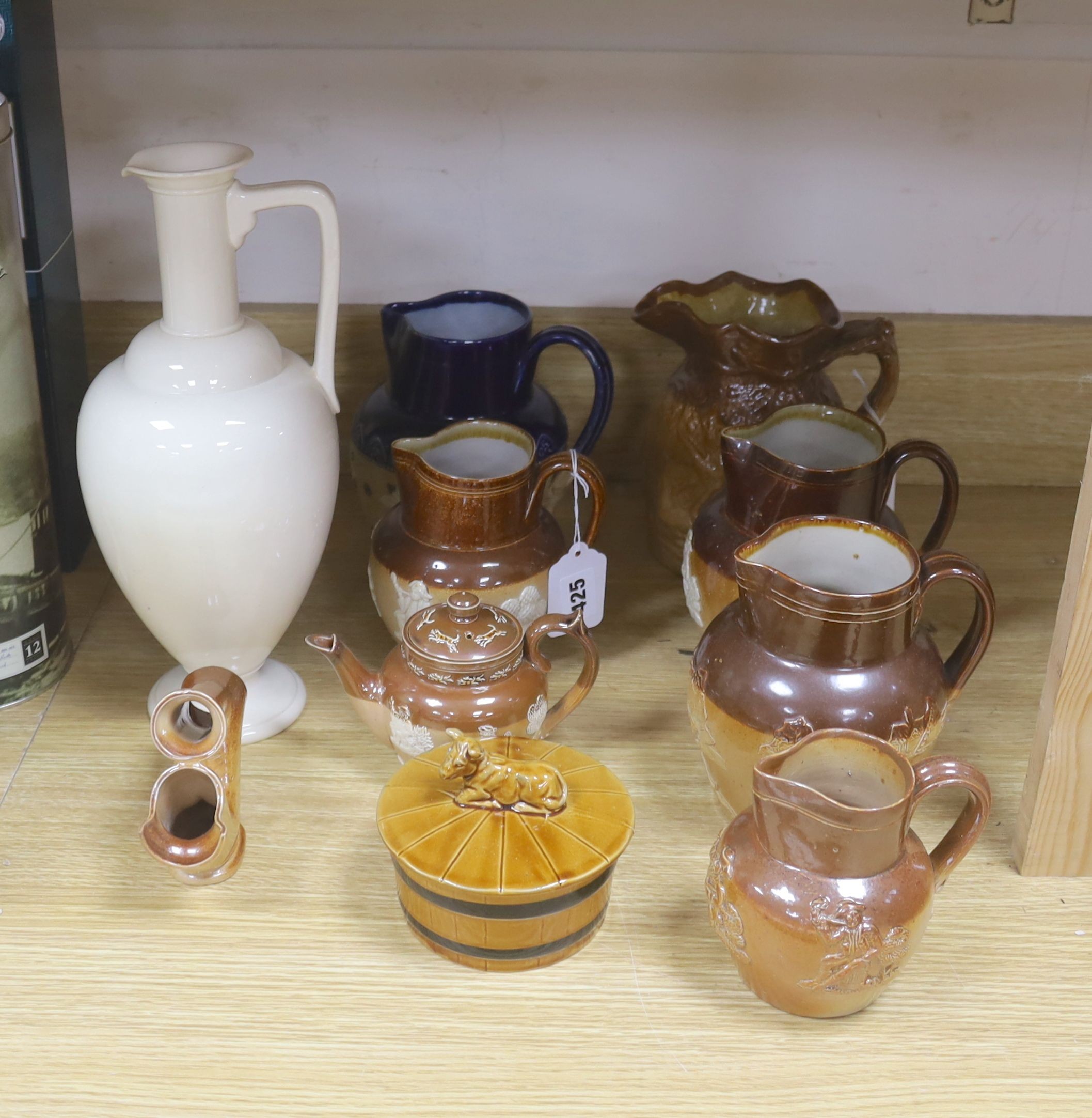 A group of Doulton stoneware: jugs, a teapot, butter dish and a pipe salesman's model